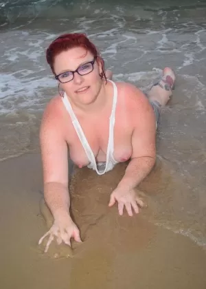 Зрелая рыжая Молли Фокс смачивает свое татуированное тело в океане