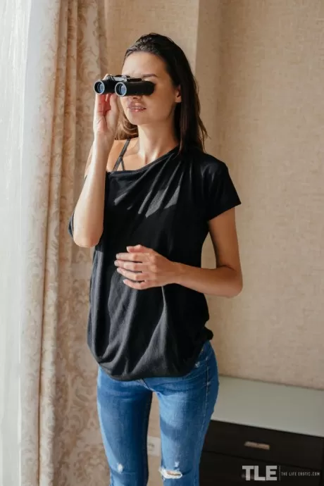 Стройная молоденькая Кристин мастурбирует, подглядывая за своими соседями в бинокль
