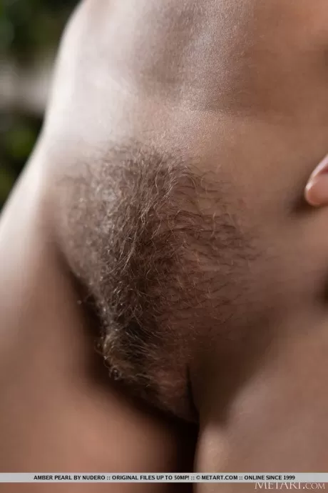 Красивая девушка Эмбер Перл принимает великолепные обнаженные позы рядом с цветами