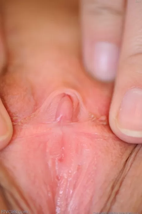 Обнаженная соло девушка с приятным лицом и улыбкой широко раздвигает свои половые губки