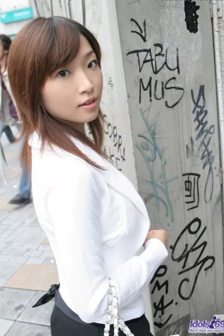 Молодая японская девушка Кото сидит на сиденье унитаза после раздевания