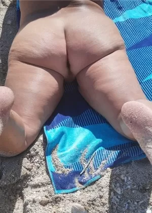 Пожилая любительница Дебби Делишес загорает в тени на нудистском пляже