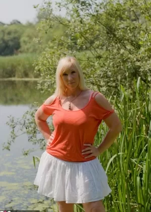 Толстая блондинка с большой грудью Мелоди раздевается на причале у озера