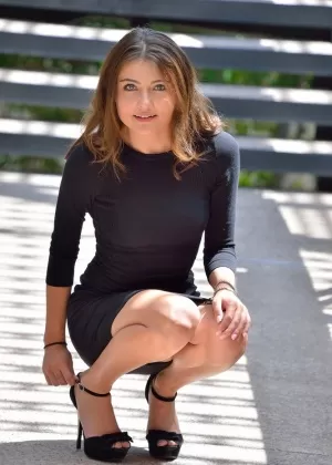 Молодая милашка в обтягивающем платье и на каблуках вставляет большой огурец в киску