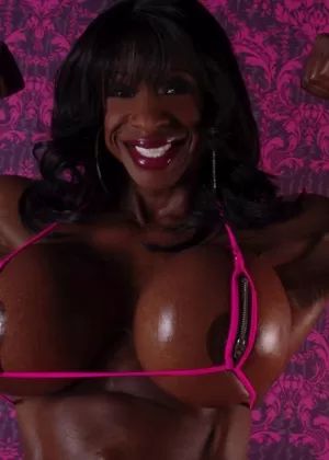 Ebony bodybuilder Yvette Bova releases her augmented breasts from a bikini