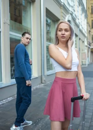 Полностью одетая брюнетка закуривает сигарету, надев на голову солнцезащитные очки