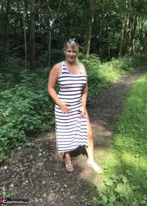 Зрелая любительница показывает свои большие сиськи и попку на скамейке в лесу
