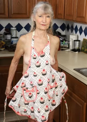 Пожилая женщина Линда Джонс обнажает свое морщинистое тело во время уборки на кухне