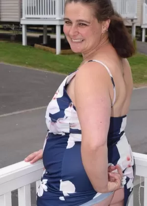 Толстушка средних лет выставляет себя напоказ на балконе в общественном месте