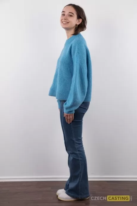 Любительская модель Ульяна стоит голая, сняв свитер и синие джинсы