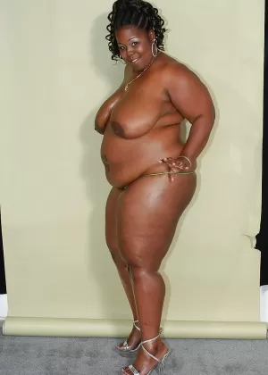 Непристойная негритянка на высоких каблуках, обнажающая свои жирные изгибы