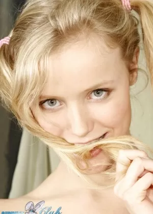 Молодо выглядящая блондинка Яна заплетает волосы в косички для своих первых обнаженных фотографий