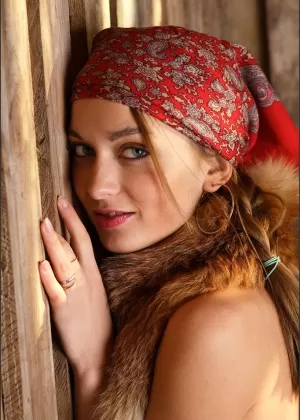 Adorable farm girl models naked in a barn with a fox draped around her