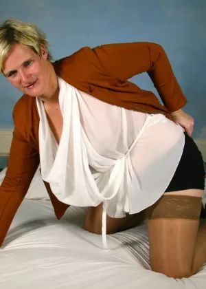 Fat Dutch housewife with short hair strips to tan stockings on her bed