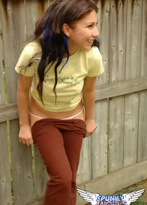 Молодая брюнетка дебютирует обнаженной моделью на фоне забора на заднем дворе