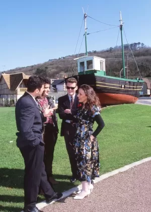 Brunette woman licks cum from red lips at the end of a gangbang