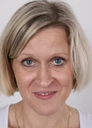 Зрелая женщина скрещивает ноги после того, как сняла всю свою одежду