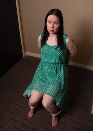 Расстроенную зрелую женщину в платье в горошек связали с кляпом во рту для БДСМ-забавы