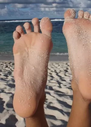 Длинноногая девушка показывает подошвы своих ног после подводного плавания топлесс