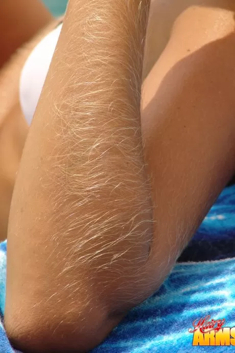 Любитель средних лет с волосатыми руками модели в бикини рядом с океаном