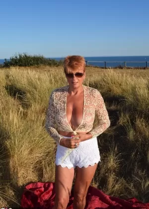 Подтянутая пожилая леди Даймонти обнажает большие натуральные сиськи на одеяле с видом на океан