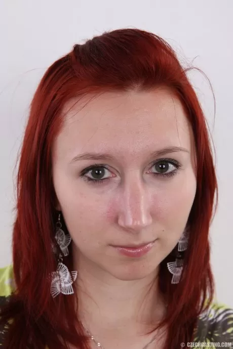 Рыжеволосая любительница Моника садится на табурет после того, как постояла голышом