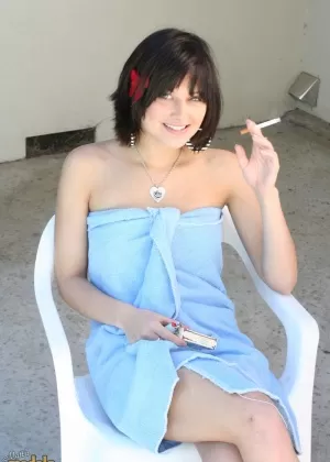 Брюнетка милфа Элли Идол освобождает свое обнаженное тело от банного полотенца во время курения