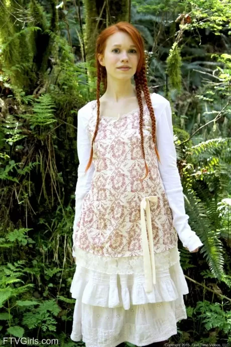 Молодая рыжеволосая девушка с косичками и в сапогах занимается йогой обнаженн 1