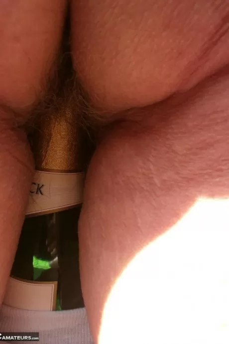 Похотливая старая Каро на открытом воздухе в сапогах раздвигает киску, чтобы поиграть с бутылкой вина