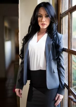 Темноволосая женщина сбрасывает блейзер и юбку, чтобы позировать обнаженной перед витриной