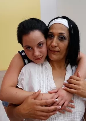 Old and young lesbians kiss while getting completely naked on their bed